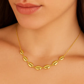 colar-dourado-no-pescoco-com-buzios-autoral-e-elegante